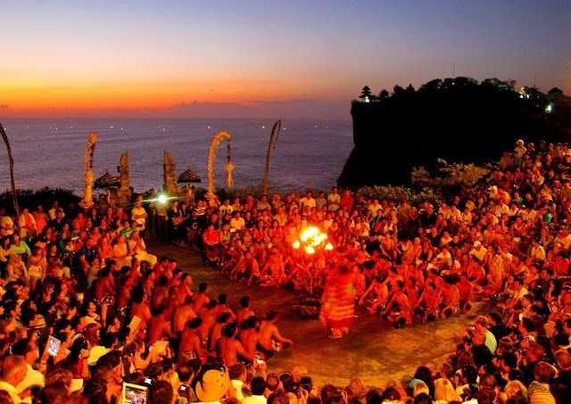 Kecak dance with a sunset over the Indian Ocean behind the perched cliff-edge Uluwatu Temple in Bali.