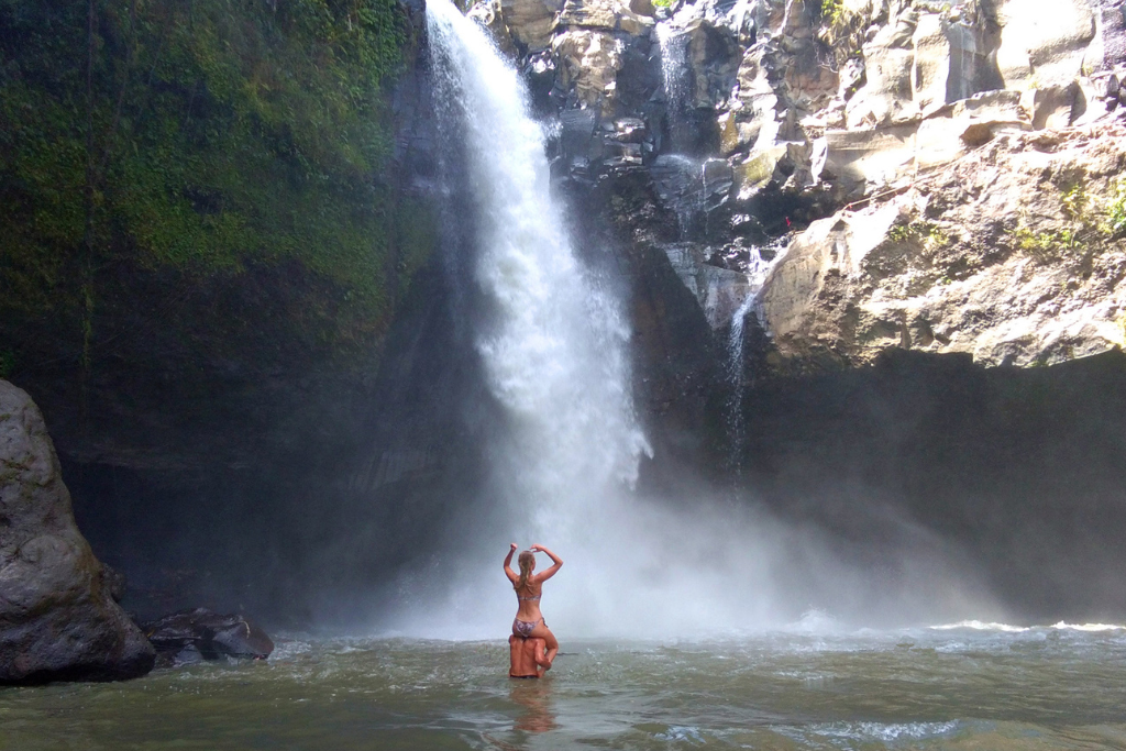 The scenic Tegenungan Waterfall near Ubud, surrounded by lush tropical greenery and a natural swimming pool.